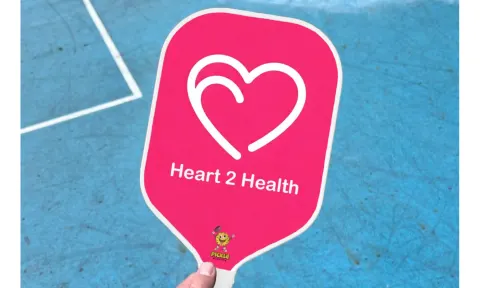 A custom pink paddle with a heart logo